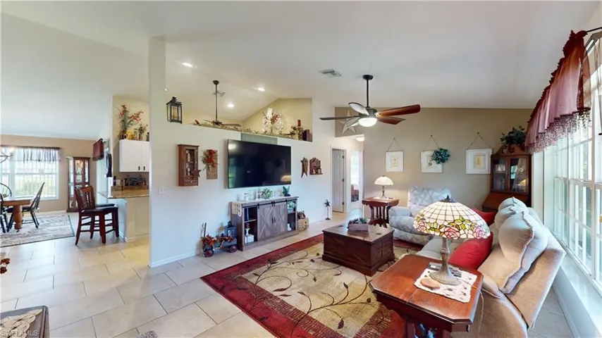 Tiled living room featuring lofted ceiling and ceiling fan