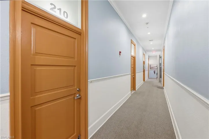 Corridor with light carpet, recessed lighting, and crown molding