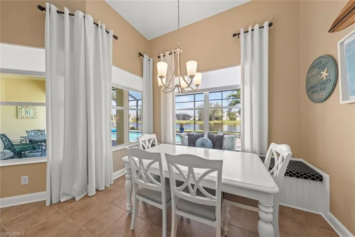 Dining space with breakfast knook,chandelier, tile patterned floors, a water view, and a healthy amount of sunlight