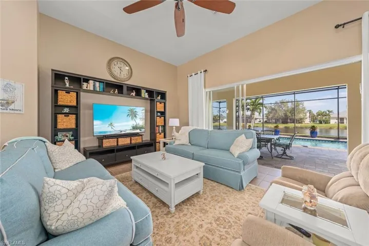 Living area with tile, a ceiling fan, and a wealth of natural light & sliding glass doors to pool area