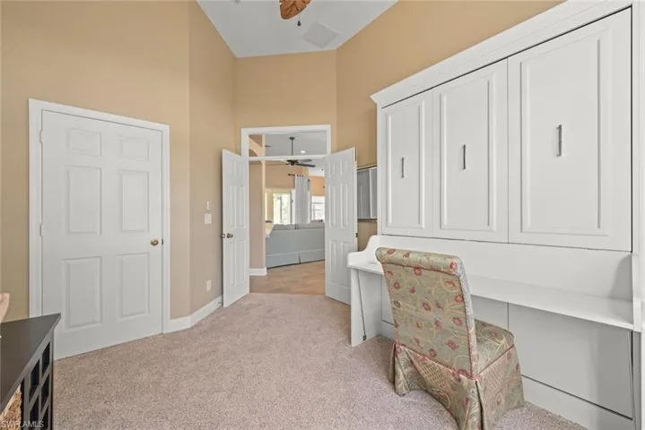 4th Bedroom/Office flex space area featuring light , Murphy bed -desk,carpet, baseboards, ceiling fan, and a high ceiling