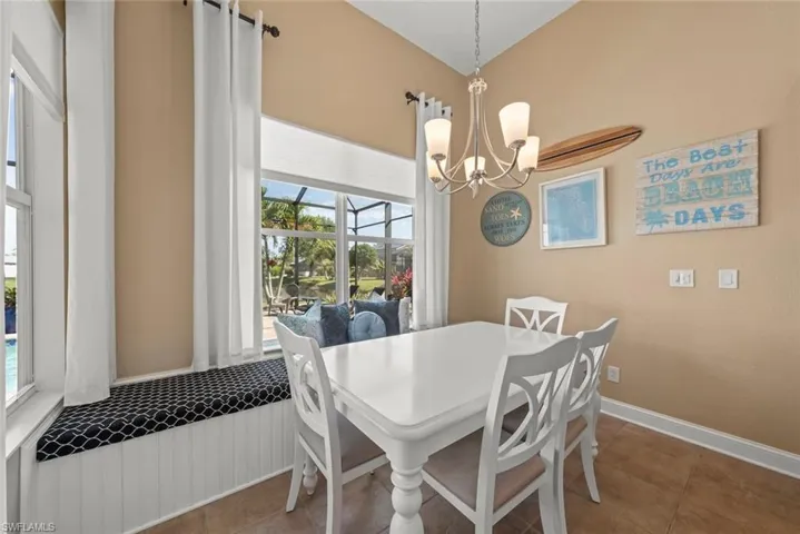 Dining room with a healthy amount of sunlight, tile patterned flooring, and a chandelier