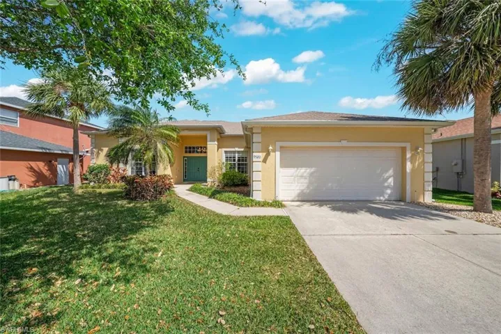 Ranch house with an attached garage, concrete driveway, a front lawn, and stucco siding