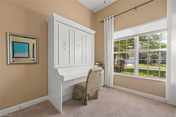 4th Bedroom/Office flex space area featuring light carpet, Murphy bed-desk, baseboards, ceiling fan, and a high ceiling & a healthy amount of sunlight