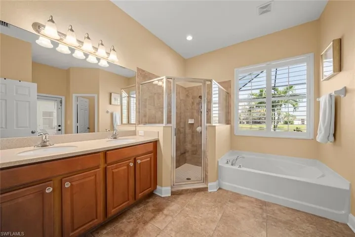 Primary bath featuring dual sinks, shower & a garden tub