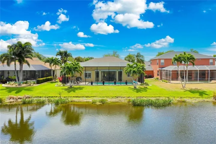 Rear view of property featuring a water view and a yard