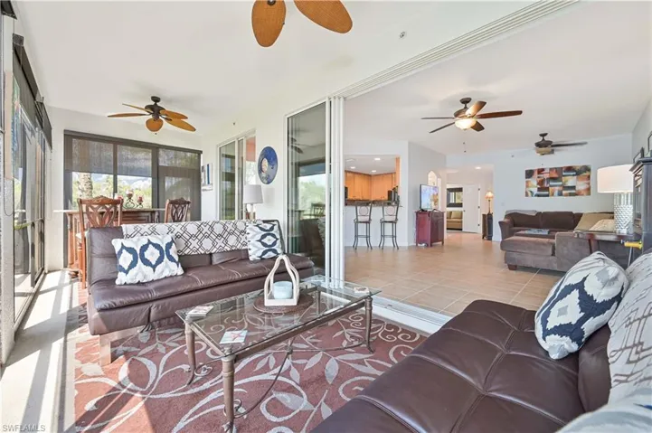 Living room featuring light tile patterned floors and ceiling fan