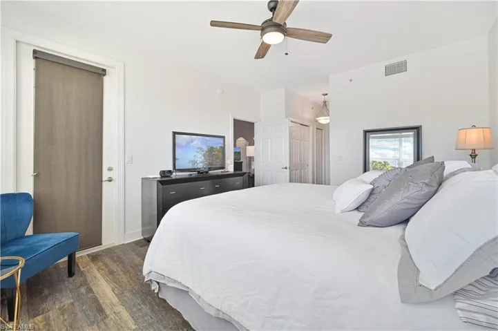 Bedroom with a closet, dark wood-style flooring, and ceiling fan
