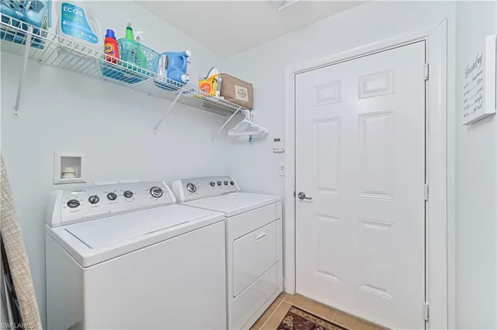 Laundry room featuring washing machine and dryer and light tile patterned flooring