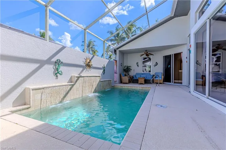 Swimming pool featuring a ceiling fan, a lanai, a patio area, a sunroom, and an outdoor hangout area