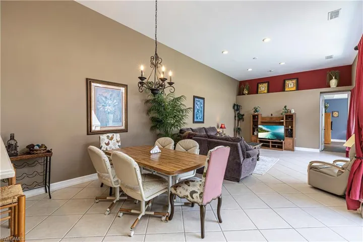 Dining space with light tile patterned floors, a chandelier, and recessed lighting