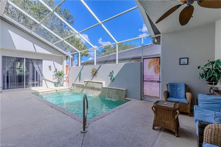 View of pool featuring a patio area, glass enclosure, a sunroom, and ceiling fan