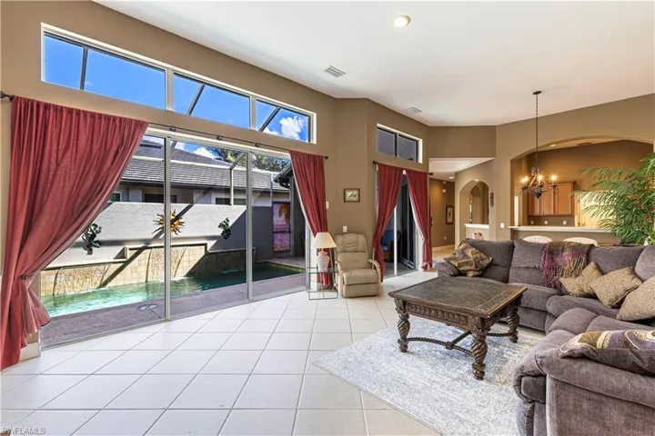 Living area with a chandelier, recessed lighting, light tile patterned floors, and arched walkways