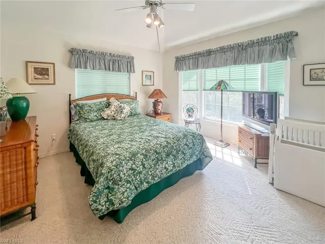 Carpeted bedroom featuring lofted ceiling and ceiling fan