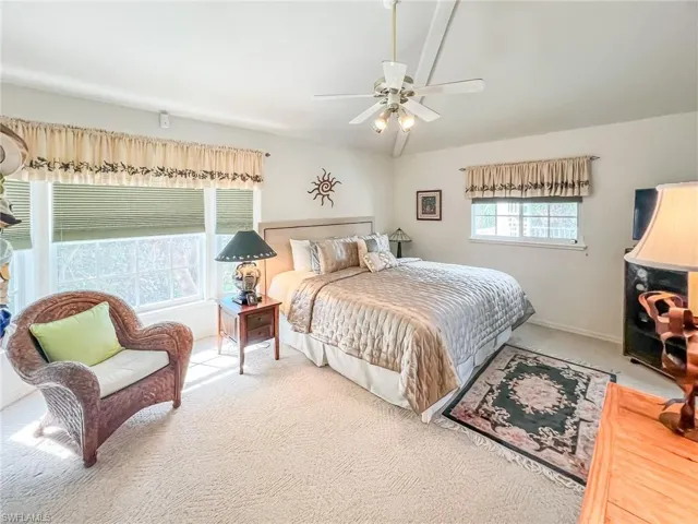 Carpeted bedroom with a ceiling fan