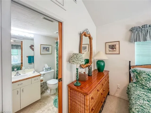 Bathroom featuring baseboards, visible vents, vanity, and toilet