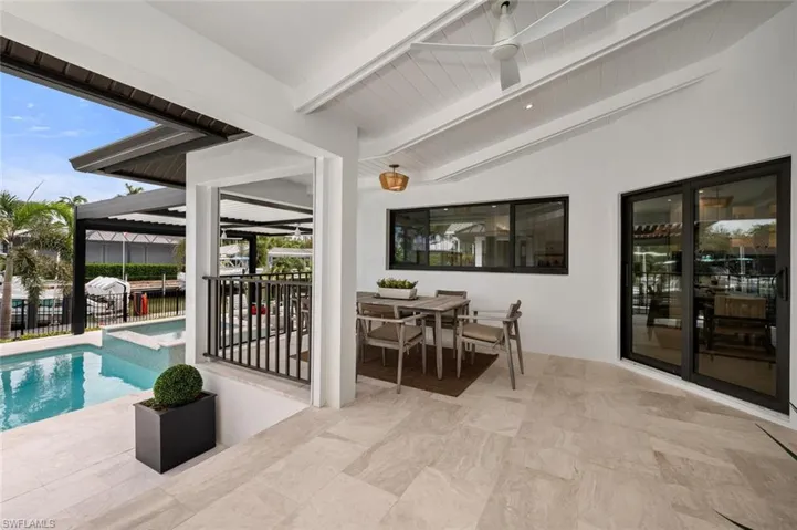 View of patio / terrace with an outdoor pool, fence, and outdoor dining area
