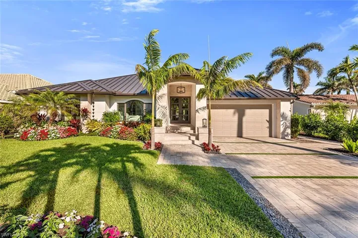 Mediterranean / spanish-style home with metal roof, an attached garage, decorative driveway, stucco siding, and a standing seam roof