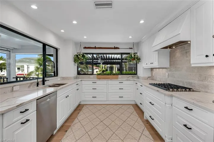 Kitchen featuring stainless steel appliances, a sink, visible vents, white cabinets, and backsplash