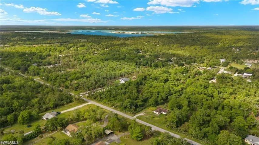 Birds eye view of property with a water view and a forest view