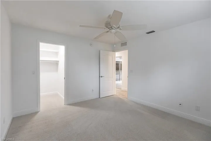 Carpeted spare room featuring ceiling fan