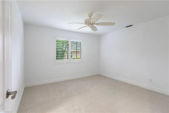 Carpeted empty room with ceiling fan