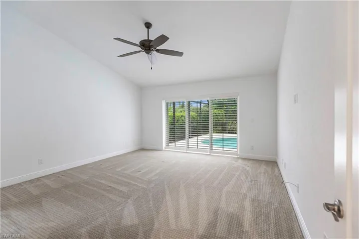 Unfurnished room featuring light carpet, lofted ceiling, and ceiling fan