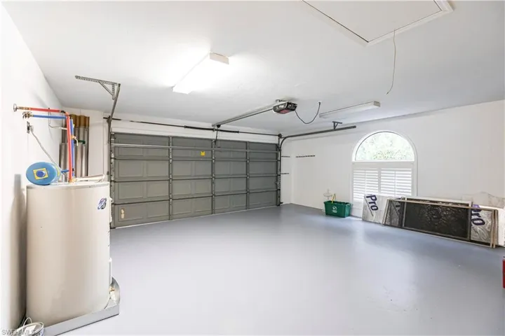Garage featuring gas water heater and a garage door opener