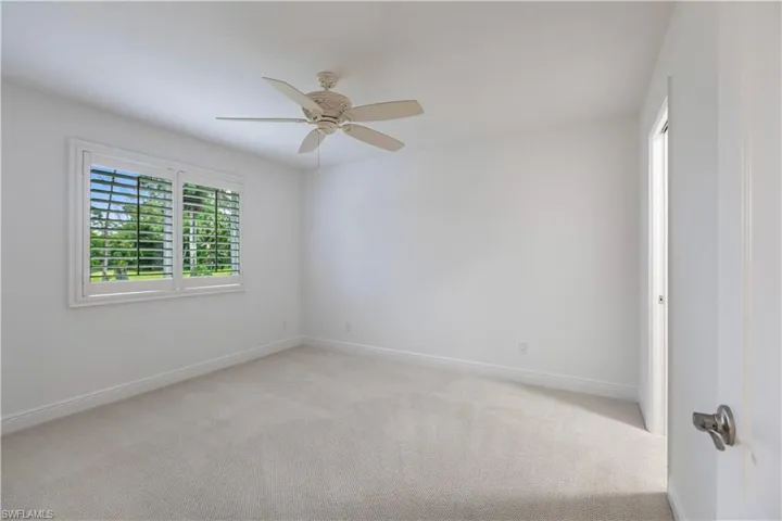 Carpeted empty room featuring ceiling fan