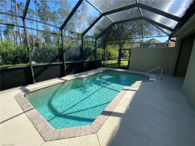 Sparkling heated swimming pool on screened lanai