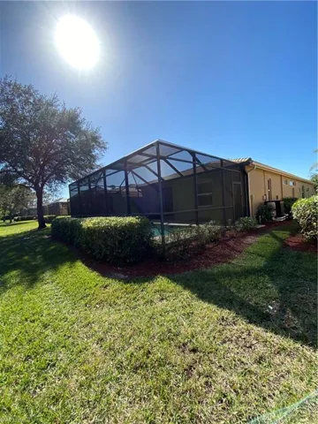 Landscaped backyard looking toward screened lanai