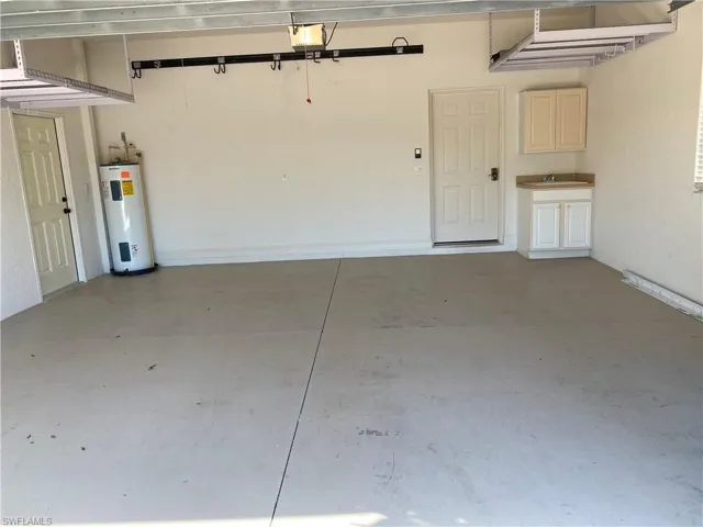 Two car garage with laundry tub and overhead storage racks