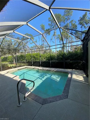 Sparkling swimming pool with view of backyard preserve area