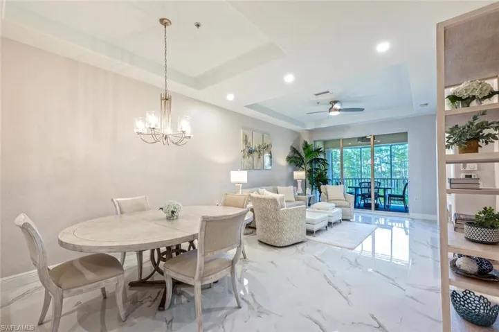 Dining room featuring tile floor, baseboards, and a tray ceiling