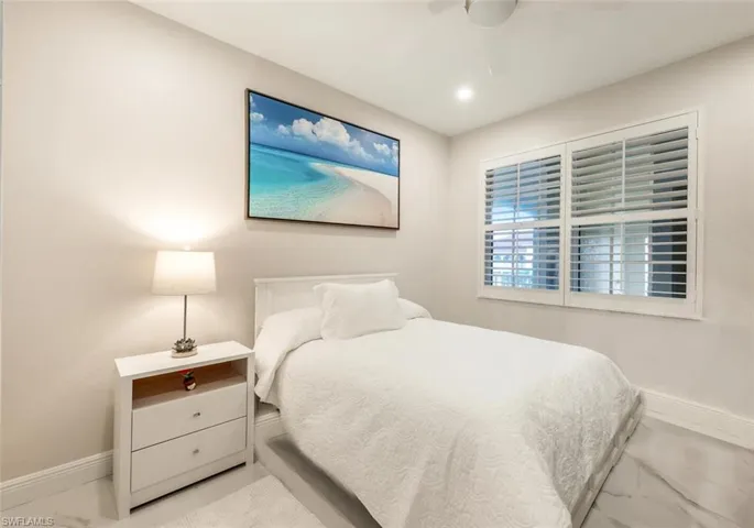 Bedroom featuring marble finish floor, ceiling fan, and baseboards
