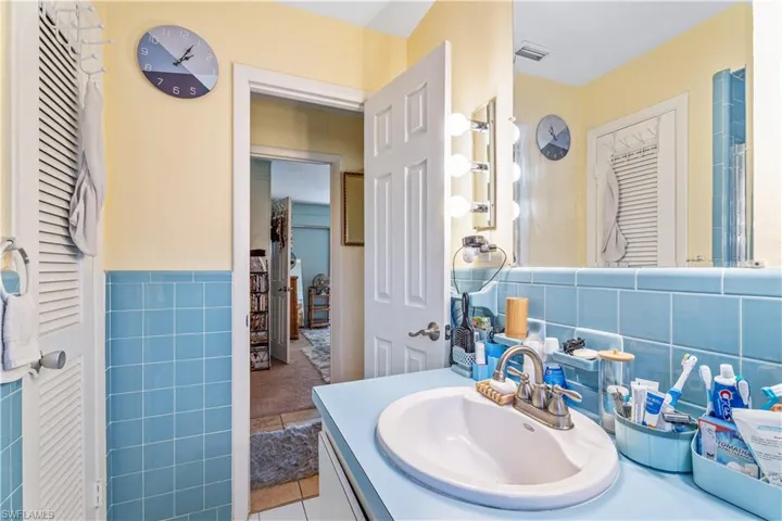Bathroom featuring tile walls, tile patterned flooring, vanity, and visible vents