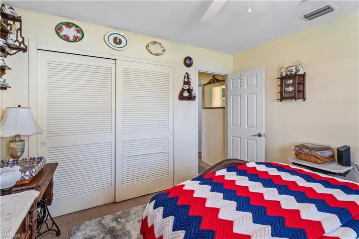 Bedroom featuring visible vents, a ceiling fan, carpet, and a closet