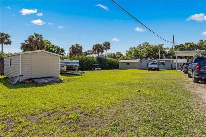 View of yard featuring a storage shed, an outdoor structure, and a carport