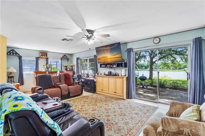 Living room with visible vents, a ceiling fan, and light tile patterned floors