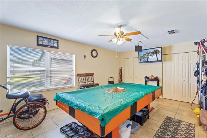 Rec room featuring light tile patterned floors, pool table, ceiling fan, and visible vents