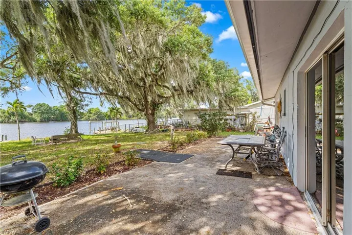 View of patio / terrace with area for grilling, a water view, and fence
