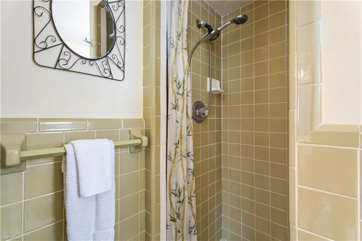 Full bathroom featuring wainscoting and a stall shower