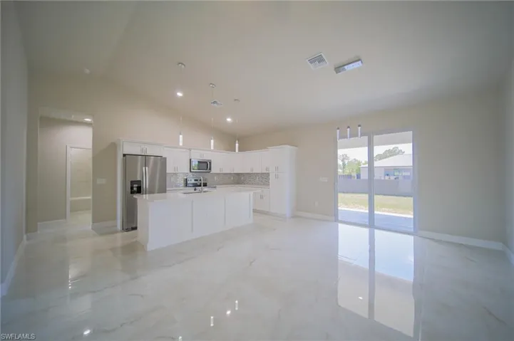 Oversized Living Room With View Into The Kitchen And Dining Area With Dual Hurricane Sliders That Lead Out To A Covered Lanai!