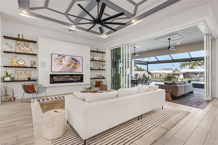 Spacious Living Area with High Tray Ceilings, Electric Fireplace and Built-In Open Shelving