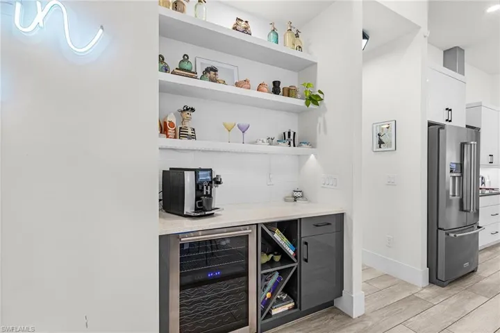 Dive Into the Built-In Bar with open shelving and a wine refrigerator (second wine refrigerator installed in kitchen island)