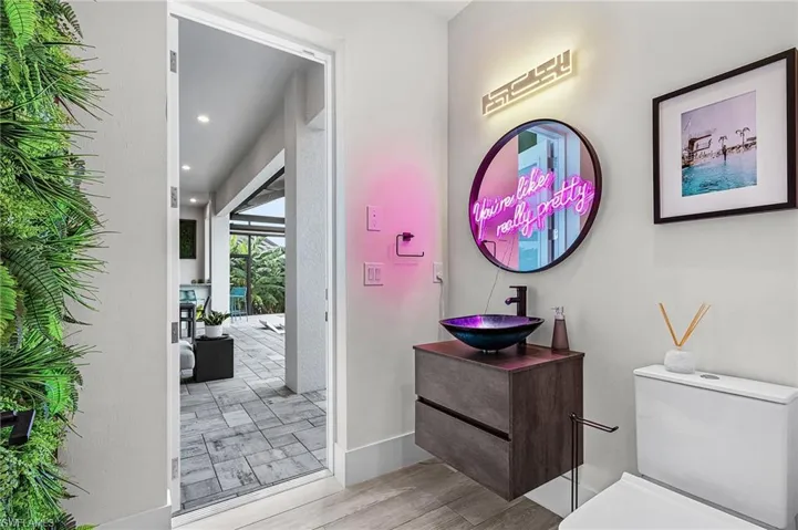 Half Bathroom for Guests with succulent wall and access to pool area