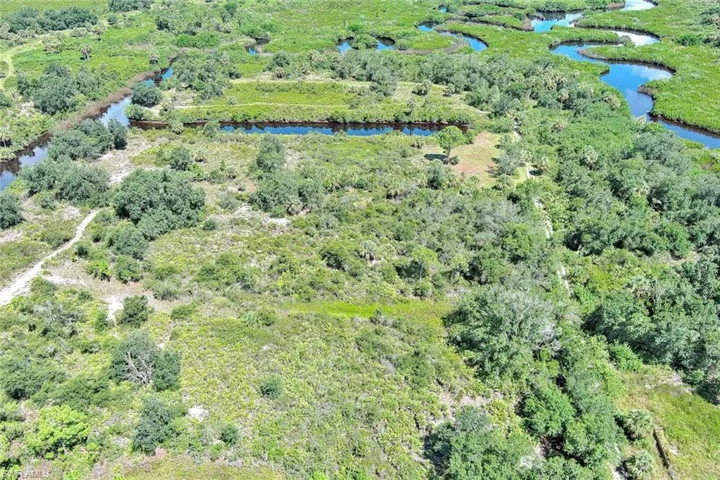 Aerial view of property and surrounding area with a nearby body of water