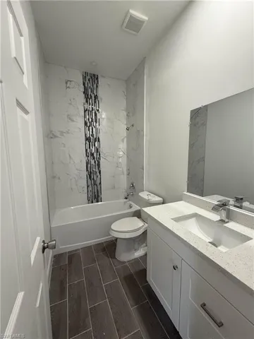 Bathroom with tub / shower combination, vanity, and wood tiled floors