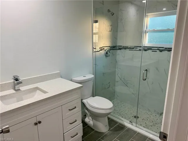 Full bathroom with vanity and a marble finish shower