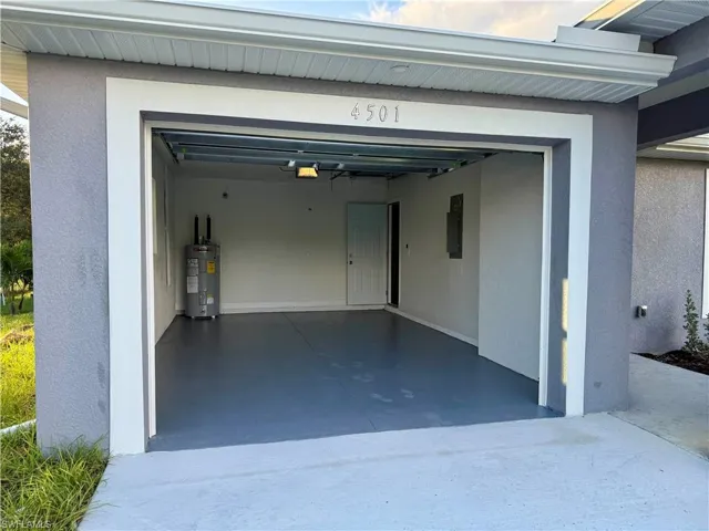 Garage featuring water heater and electric panel